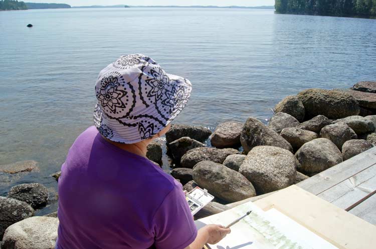 Wetting the watercolor paper before stretching it. The Puukonsaari art workshop.