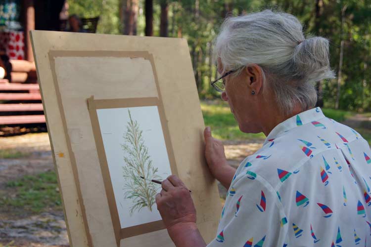 Stretching the watercolor paper with tape on plywood. The Puukonsaari art workshop.